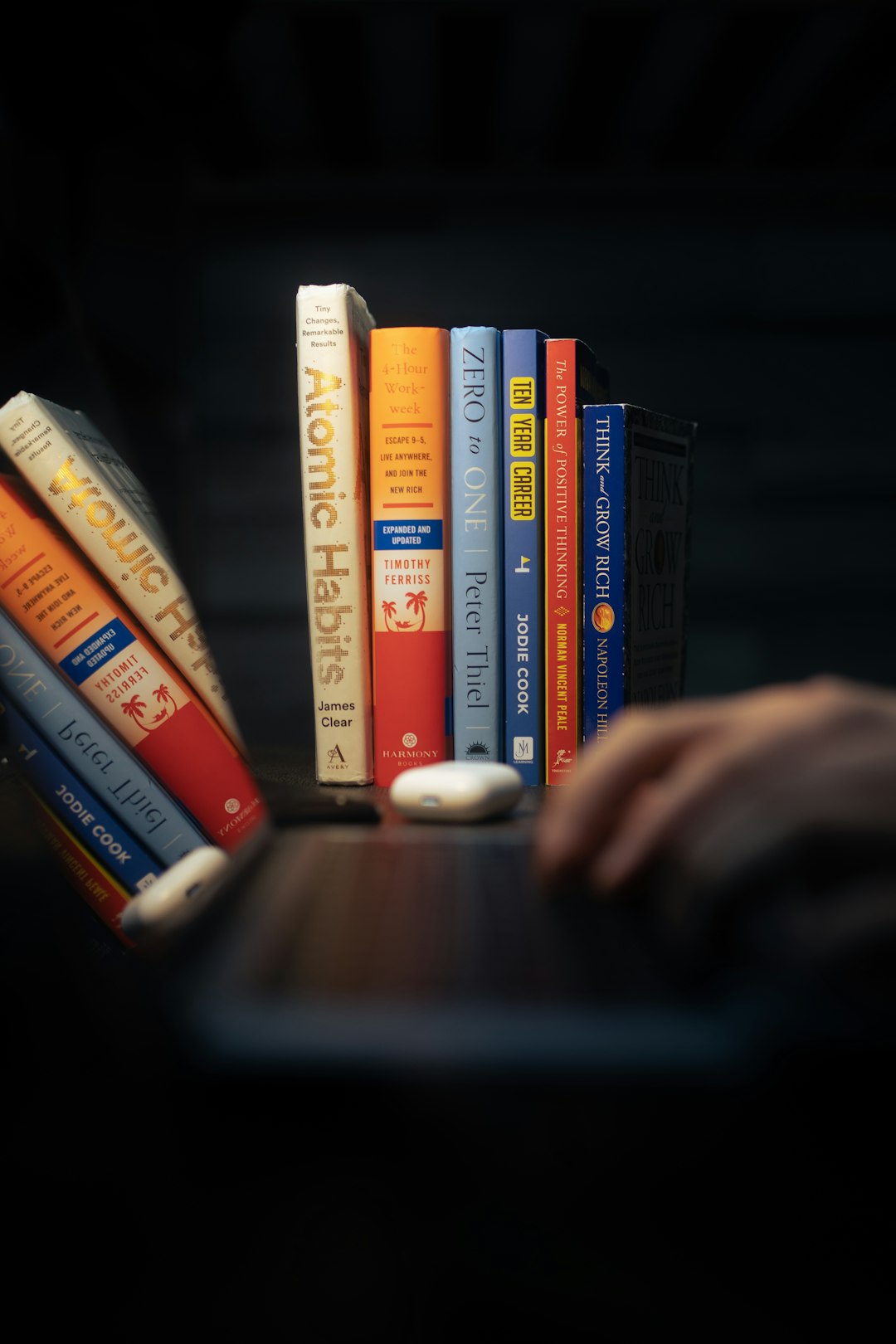 a-person-is-typing-on-a-laptop-with-a-bunch-of-books-gn9pemrzptw